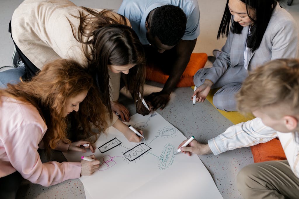 A diverse team of young adults collaborating on a startup project with brainstorming sketches.